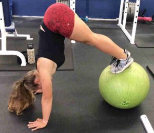 fitness female performing an advanced fit ball peak exercise