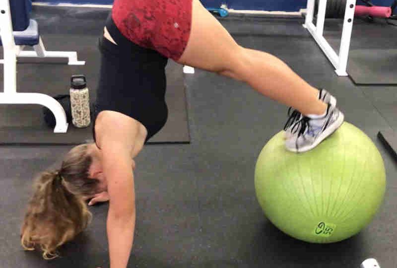 fitness female performing an advanced fit ball peak exercise