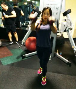 Personal Trainer Client Starting Exercise Program using cable machine pulling both arms up to center of chest