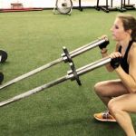 fitness client lifting two bars from a squat position