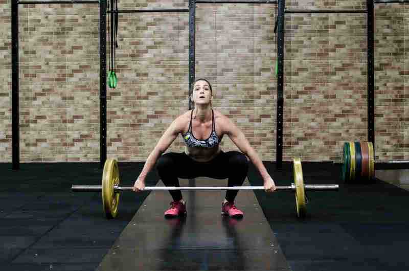 athlete preparing to clean and press a weight