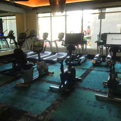 Cardio equipment room in apartment gym with windows overlooking the pool