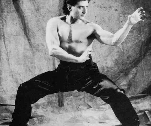 man in martial arts horse stance with hands in tiger claw position