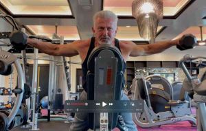 fitness trainer raising dumbbells to side